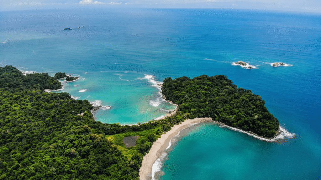 White sand and turquoise waters of Manuel Antonio Beach Costa Rica surrounded by lush rainforest wildlife