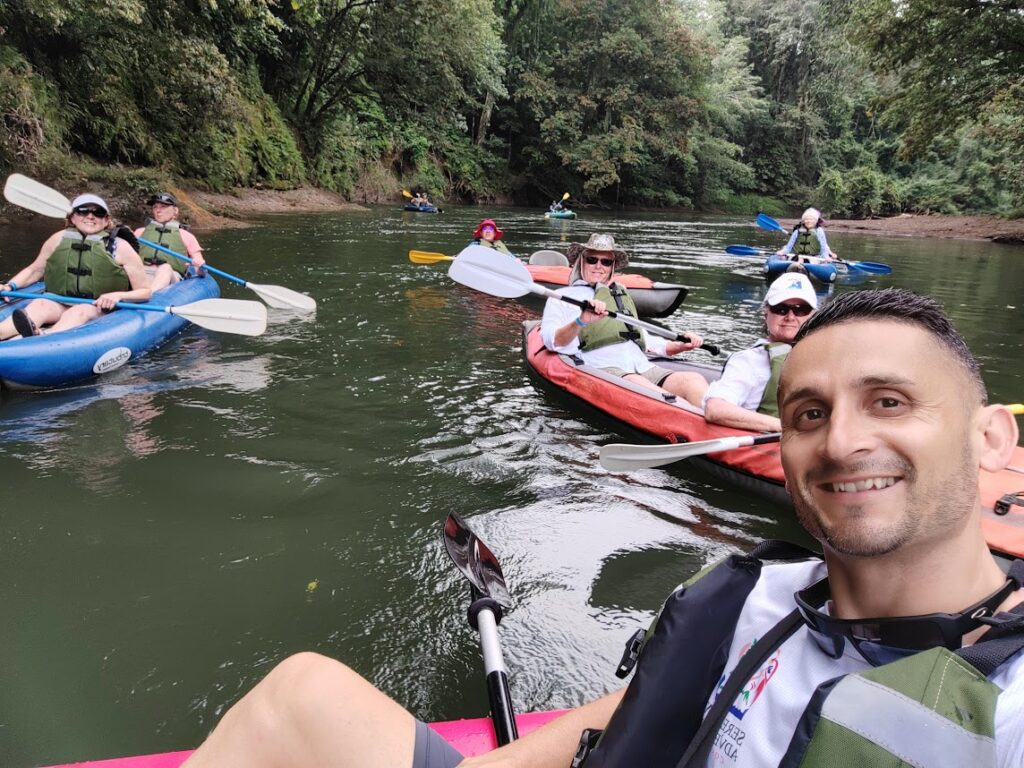Pacuare River in Costa Rica eco-tour, group of tourists kayaking with life jackets, surrounded by tropical rainforest, adventure travel and white-water experiences.