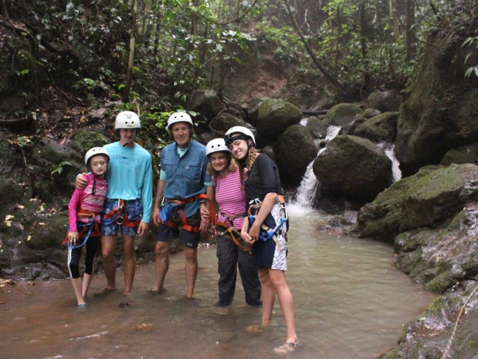 Family with helmets enjoying canyoning adventure in Costa Rica rainforest, one of the best things to do in Costa Rica with kids