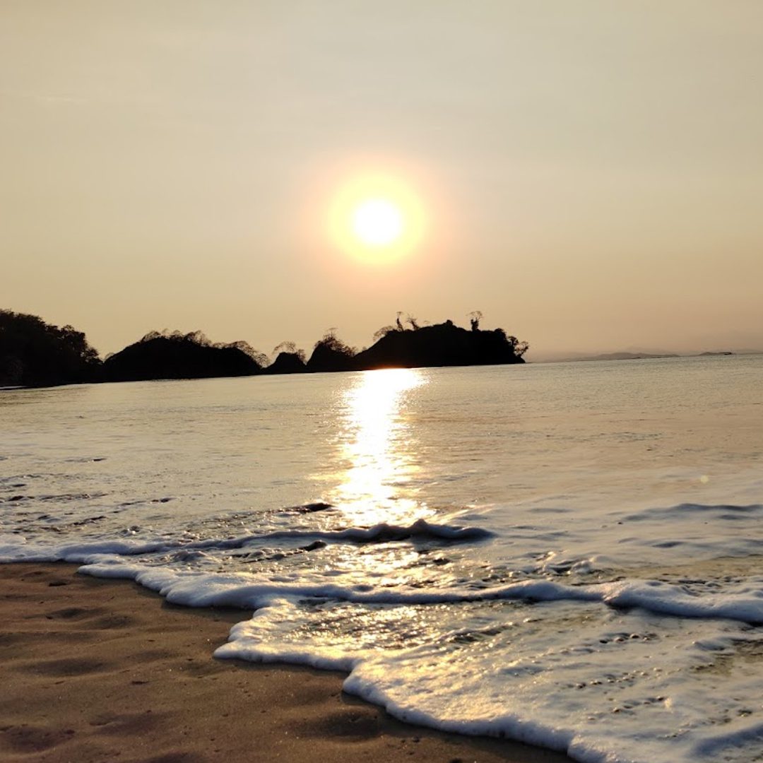 Beaches in Costa Rica, tropical white-sand shoreline with palm trees and turquoise ocean waves, perfect for relaxation and honeymoons.