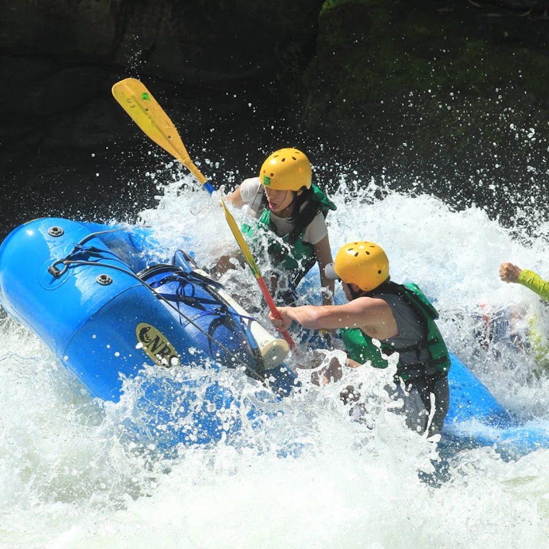 Rivers for rafting in Costa Rica, inflatable raft navigating the white-water rapids of the Pacuare River surrounded by tropical rainforest.